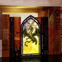 Stained-glass dragon book nook display with arch frame and warm candle-like glow