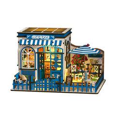 DIY miniature coffee shop house with storefront windows, blue picket fence, striped awnings