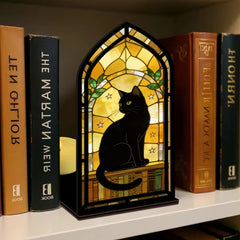 Stained-glass style black cat book nook with arched window and warm candle glow