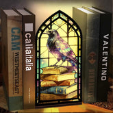 Arched book nook candle display with purple raven and stained-glass window design