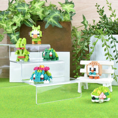 A collection of colorful, pixelated figurines or toys displayed on a shelf or stand, surrounded by potted plants and a bench.