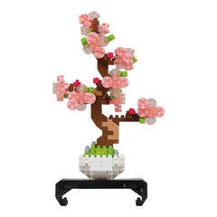 A 3D model of a pink flower arrangement in a white pot, composed of small pink and green building blocks.