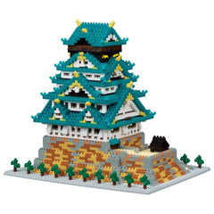 A colorful, intricate model of a traditional Japanese castle or pagoda, composed of numerous small, interlocking bricks in various shades of blue, green, and yellow.