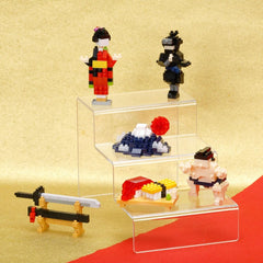 a collection of small, colorful figurines and toys arranged on three clear shelves against a yellow background.