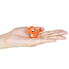 A hand holding a small orange pixelated character, likely representing a character from a video game.