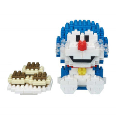 A blue and white toy resembling Doraemon, a popular character from the animated series Doraemon, is shown next to a stack of brown and white blocks.