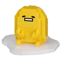 A yellow, pixelated character resembling a smiling egg with a face and arms, sitting on a white surface.