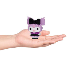 A hand holding a small, colorful, and whimsical toy figure in a purple and black color scheme.