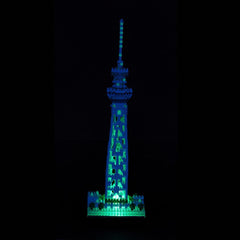 A brightly lit model of the Tokyo Skytree, a famous landmark in Japan, stands prominently against a dark background.
