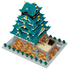 Teal castle nano building block model on a gray baseplate with green details