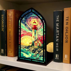 Coastal lighthouse book nook with stained-glass lighthouse panel on shelf and candle glow