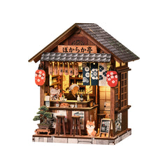 Miniature wooden pub book nook house with hanging decor, lit bar interior, and front steps