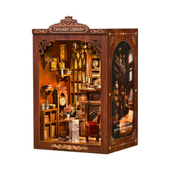 Open-front wooden DIY mini library display with lit shelves, candles, and small desk area
