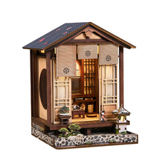 Wooden mini book nook house with open front, glowing interior, and lantern details