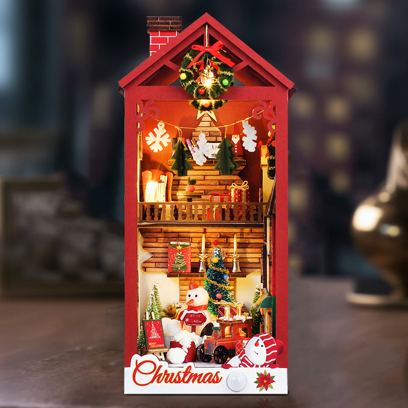 Red miniature Christmas book nook shelf insert with warm light display, wreath, trees, and snowman