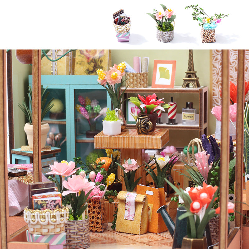Mini dollhouse greenhouse interior with potted flowers, wooden shelves, and tabletop displays.