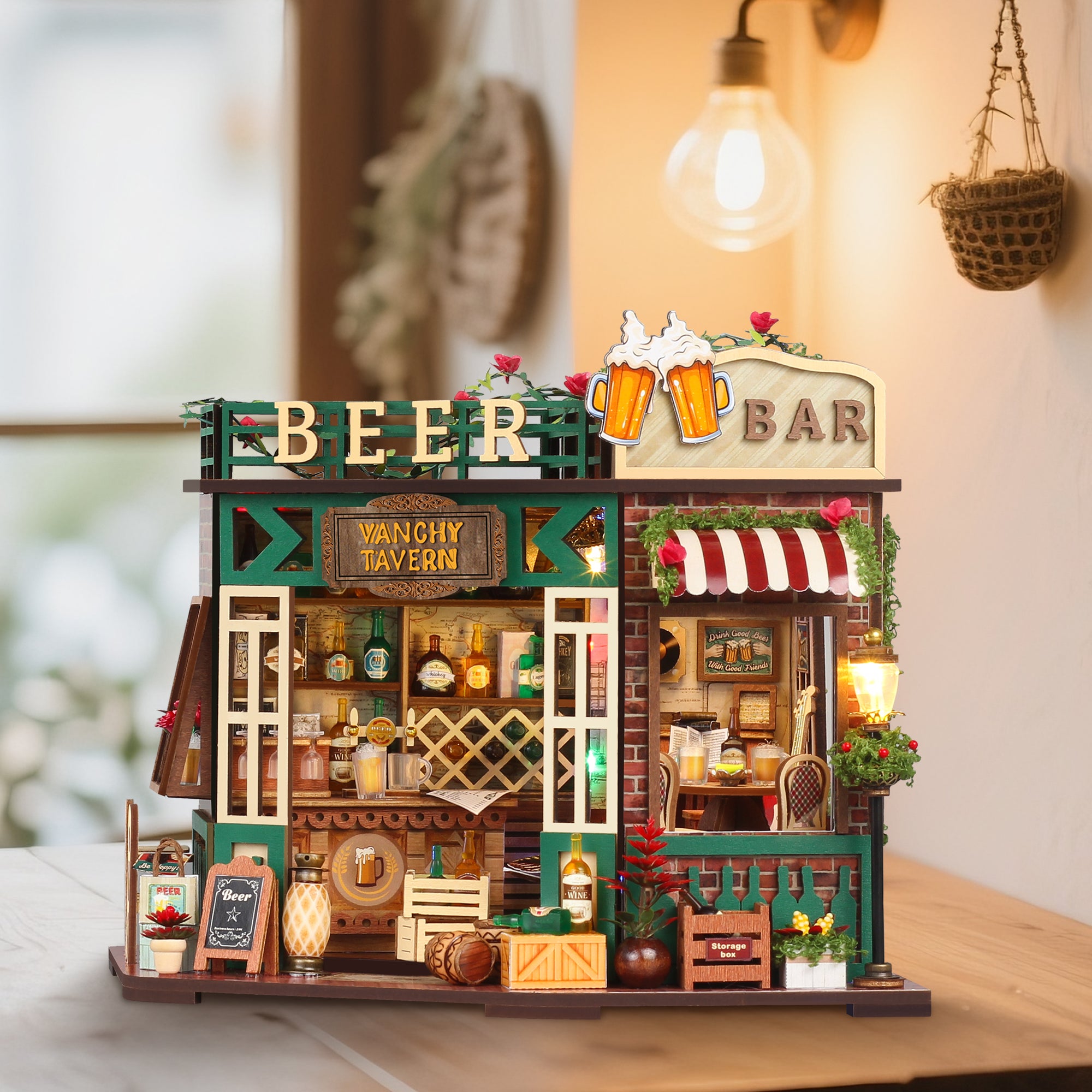 Miniature tavern beer bar dollhouse on a table with lit lamps, green doors, and front display