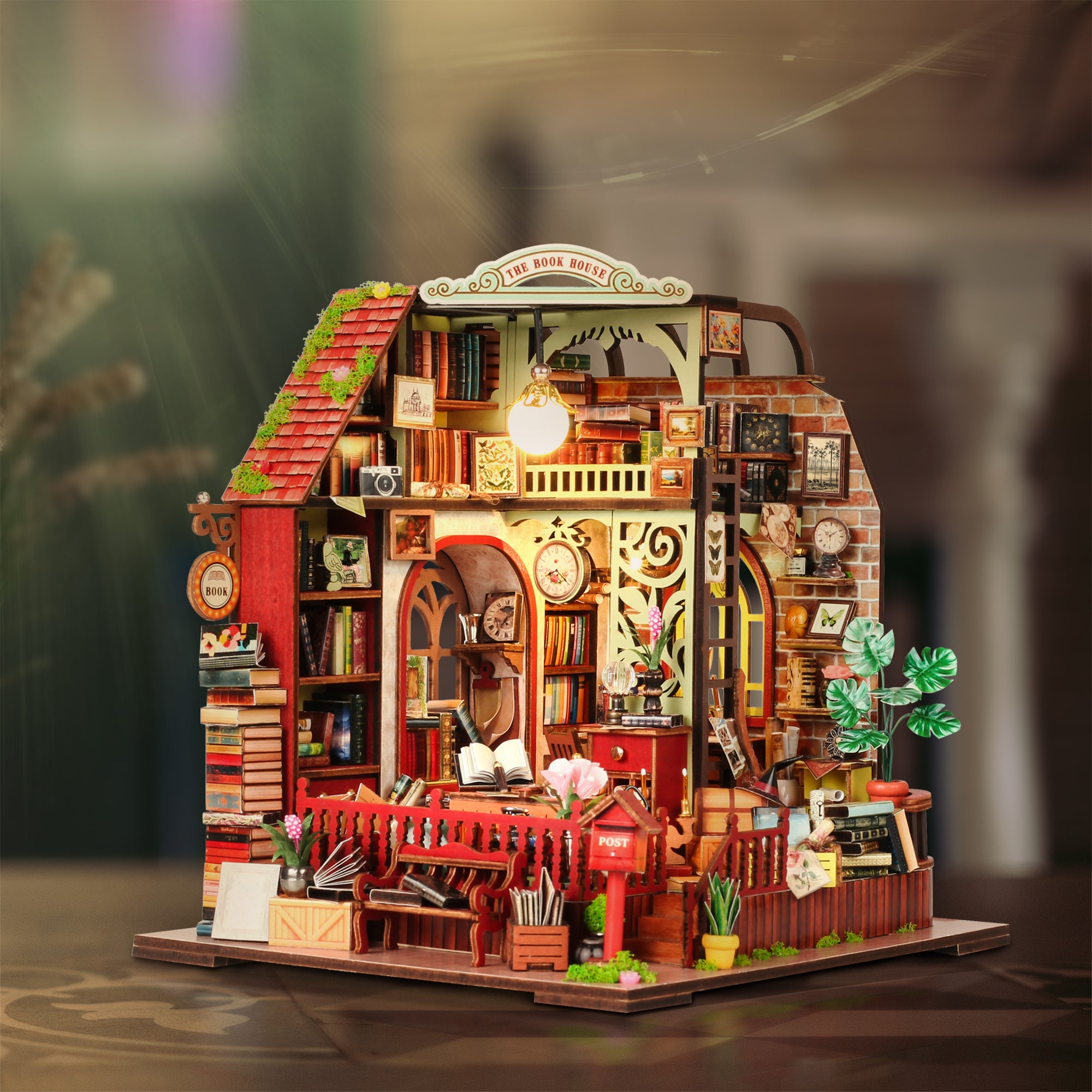 Miniature dollhouse kit front view with warm-lit interior, shelves, and red railing accents