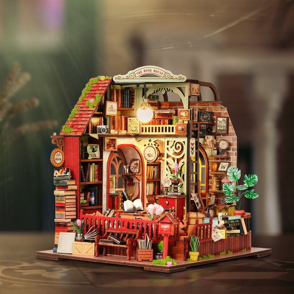 Miniature dollhouse kit front view with warm-lit interior, shelves, and red railing accents