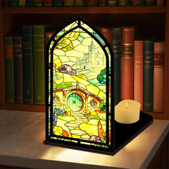 Book nook display with stained-glass style panel and small lit candle on base