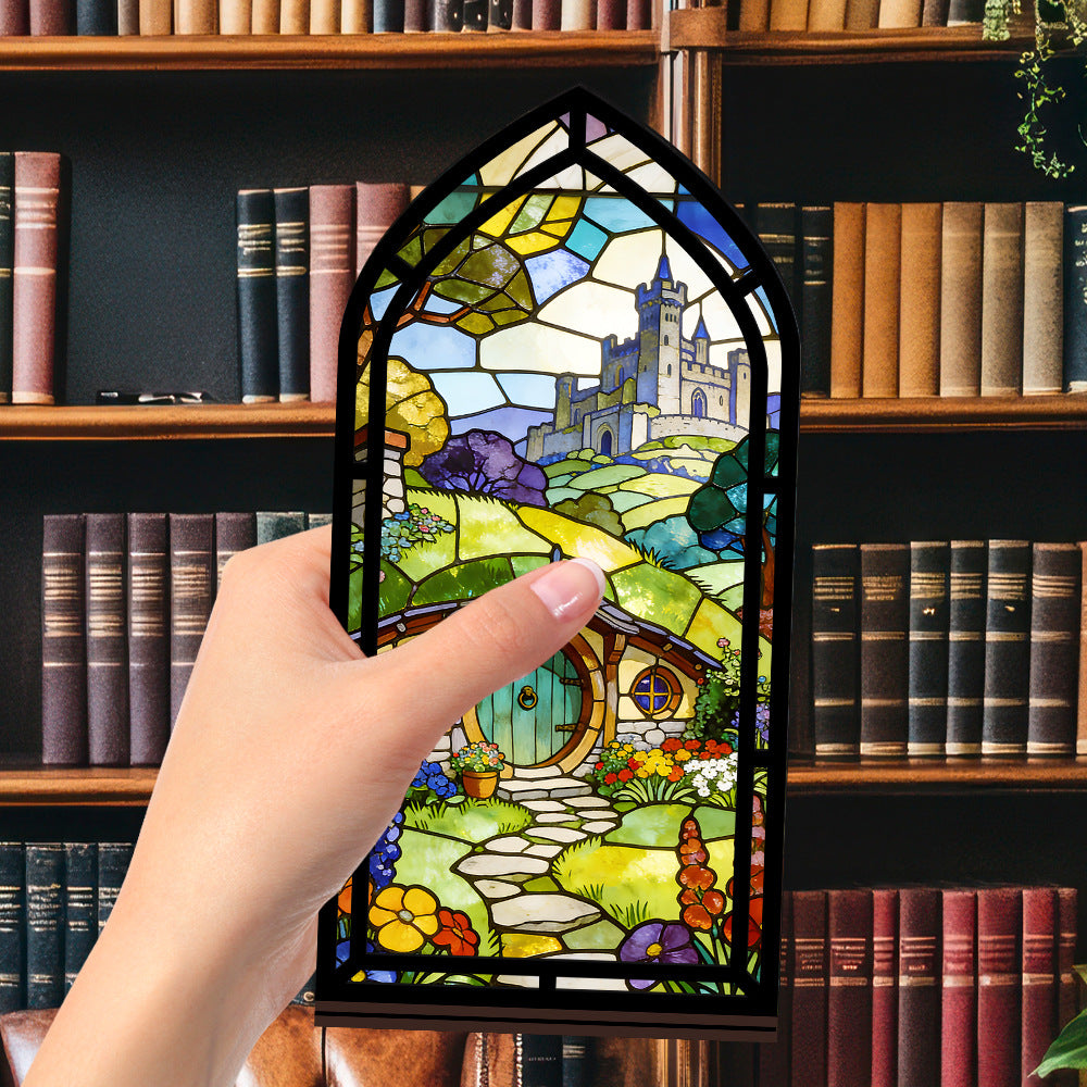 Book nook with stained-glass style panel, held by hand in front of books
