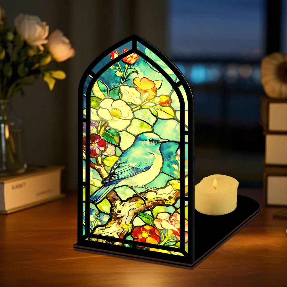 Bluebird stained-glass book nook with black frame and lit candle on the base tray