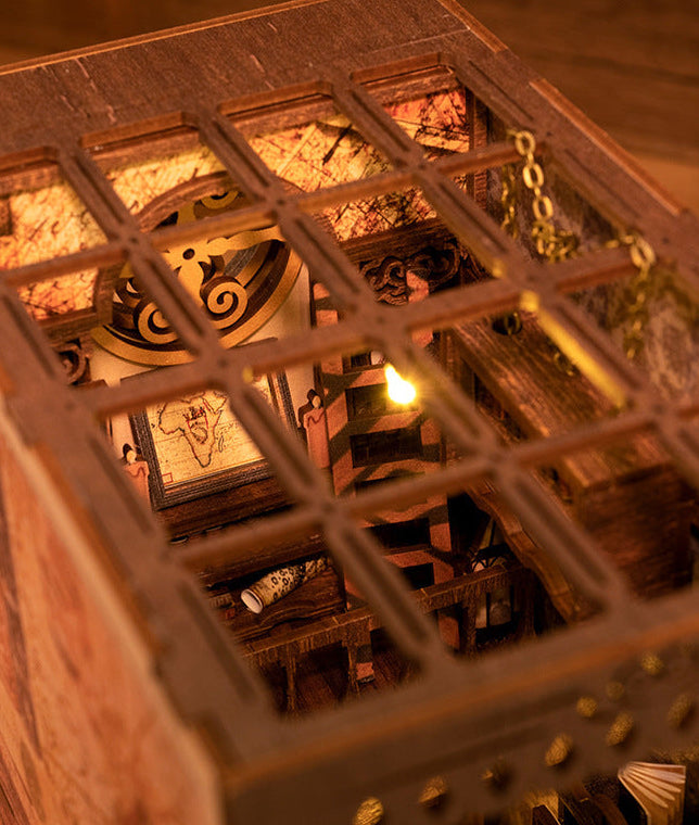 Miniature wooden bookshelf interior with carved shelves and warm hanging light