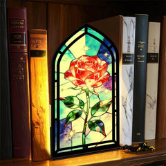 Black arched book nook with stained-glass red rose, green leaves, and starry background