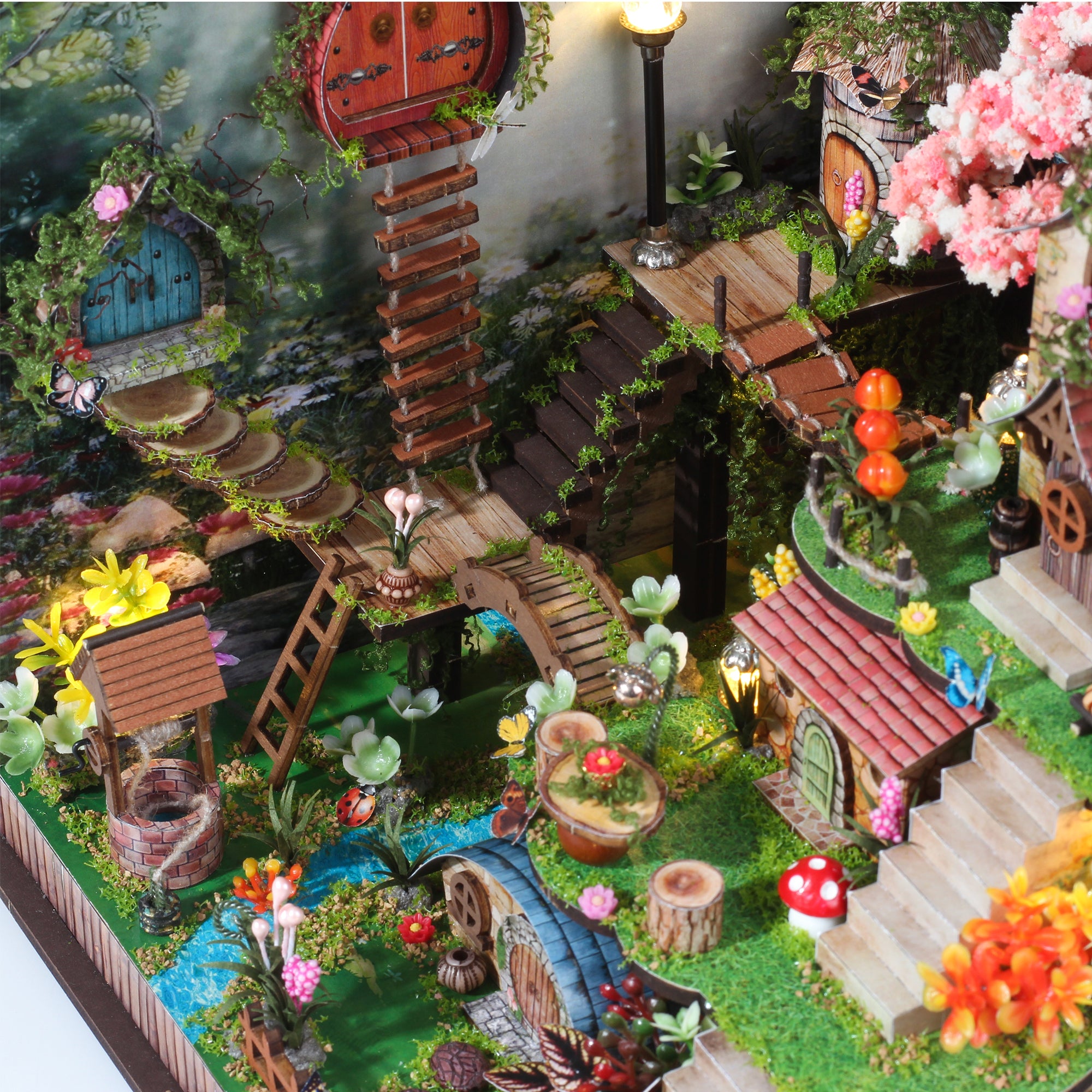 Miniature forest cabin diorama side view with stairs, stream, and blooming plants