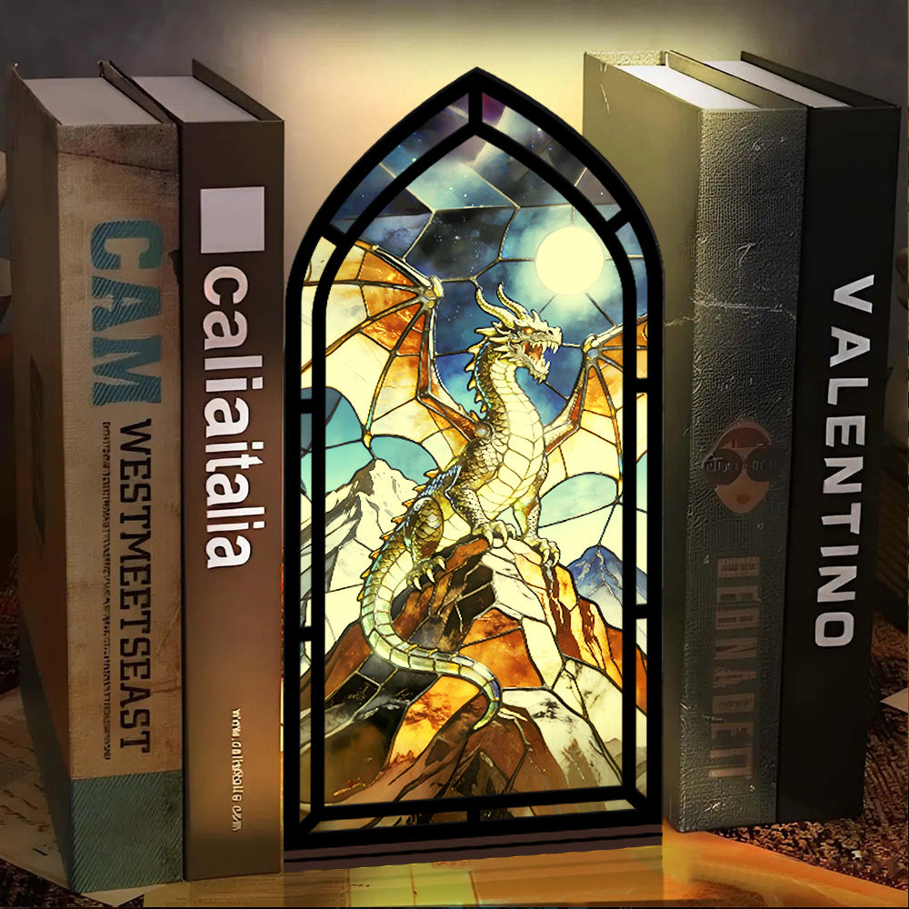 Arched stained-glass dragon book nook stand with black frame and warm candle light