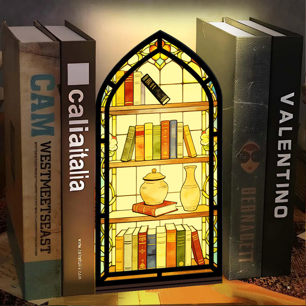 Arched illuminated book nook with faux books, teapot, and vase; shown on tabletop.