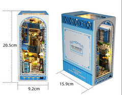 Book nook kit packaging with size diagram and arched front window showing lit room