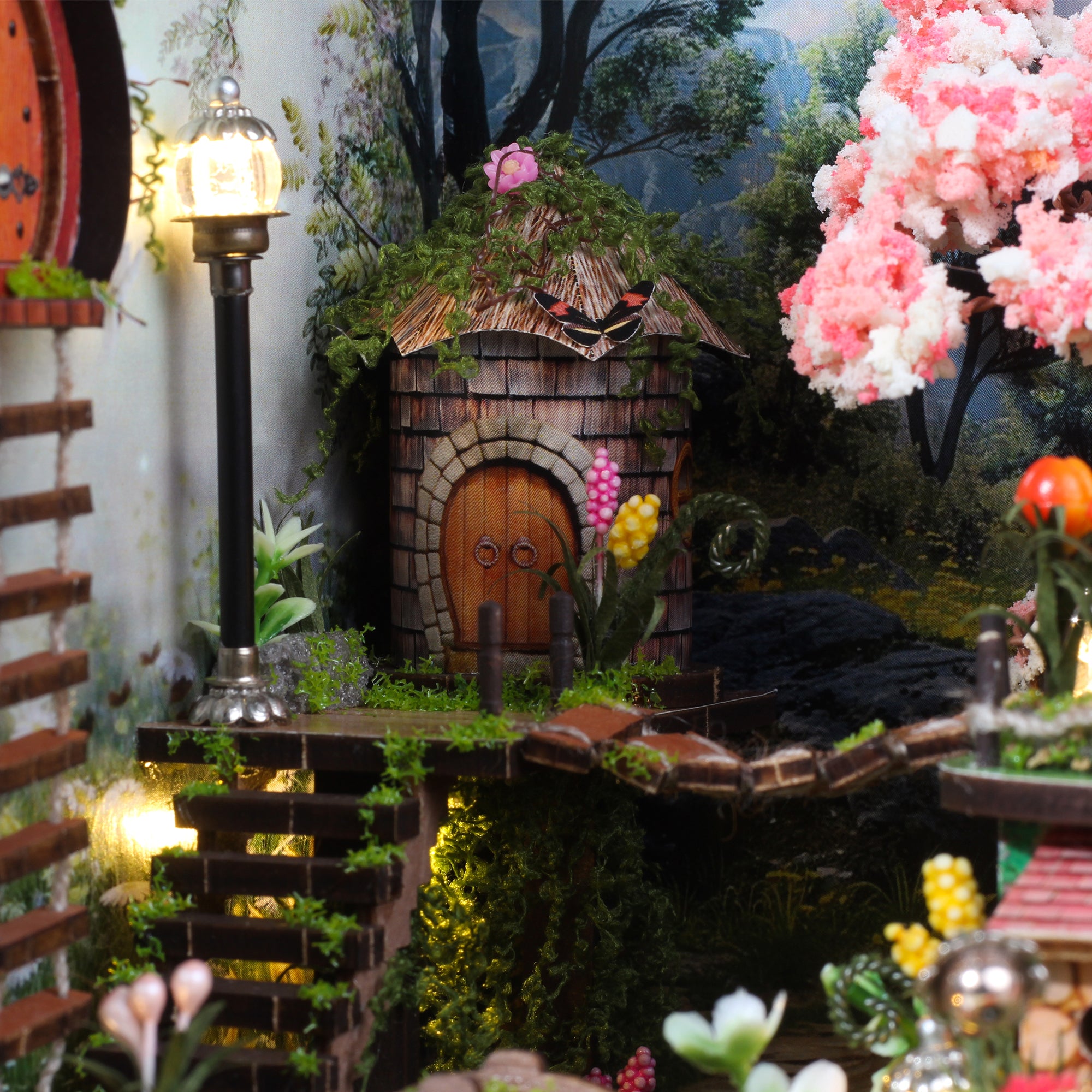 Miniature forest cabin diorama close-up with wooden door, lantern post, and pink blossoms