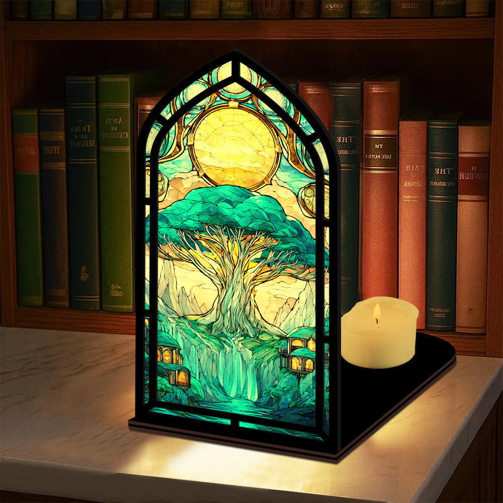 Tree-of-life book nook display with arched stained-glass tree artwork and lit candle
