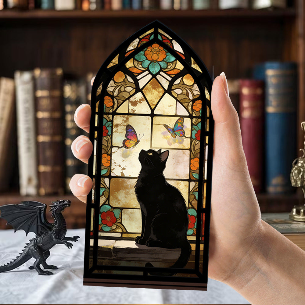 Hand holding a stained glass arched book nook with black cat silhouette and butterfly details