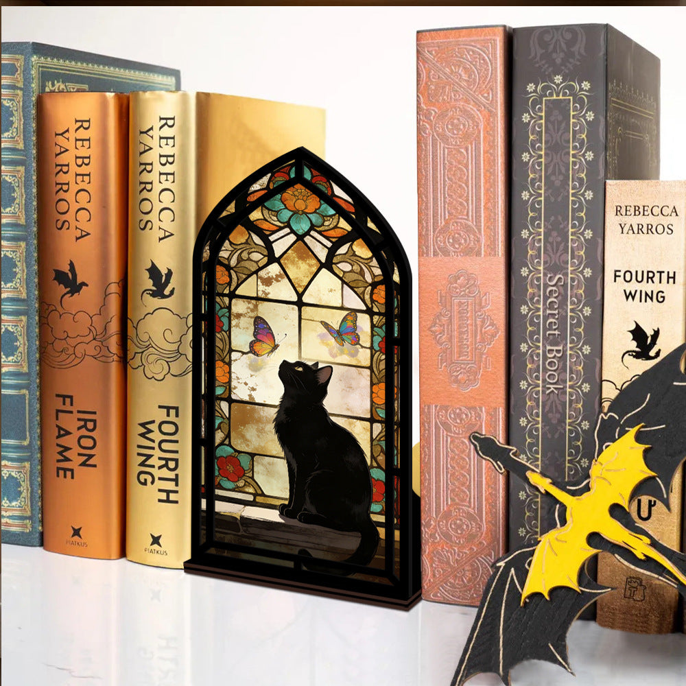 Stained glass arched book nook display with black cat silhouette, butterflies, and warm glow