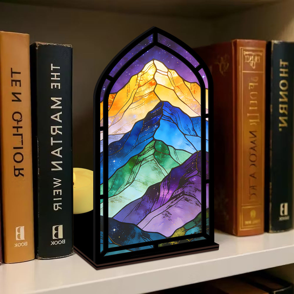 Arched illuminated mountain book nook panel with rainbow LEDs on bookshelf
