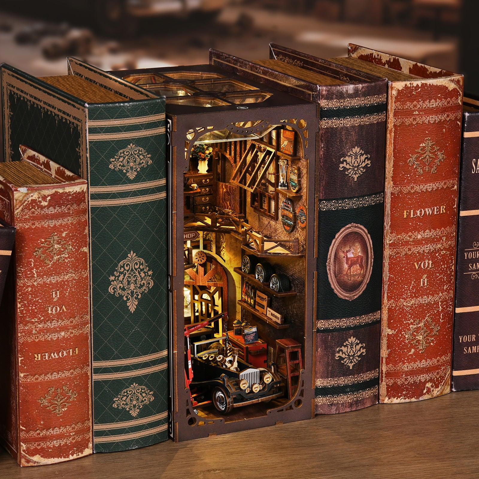 A miniature model of a car is displayed between the spines of several old books, creating a unique and visually appealing scene.