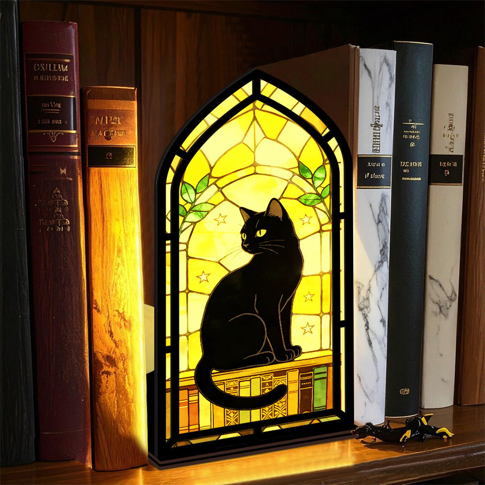 Arched black cat book nook with warm internal light, surrounded by books