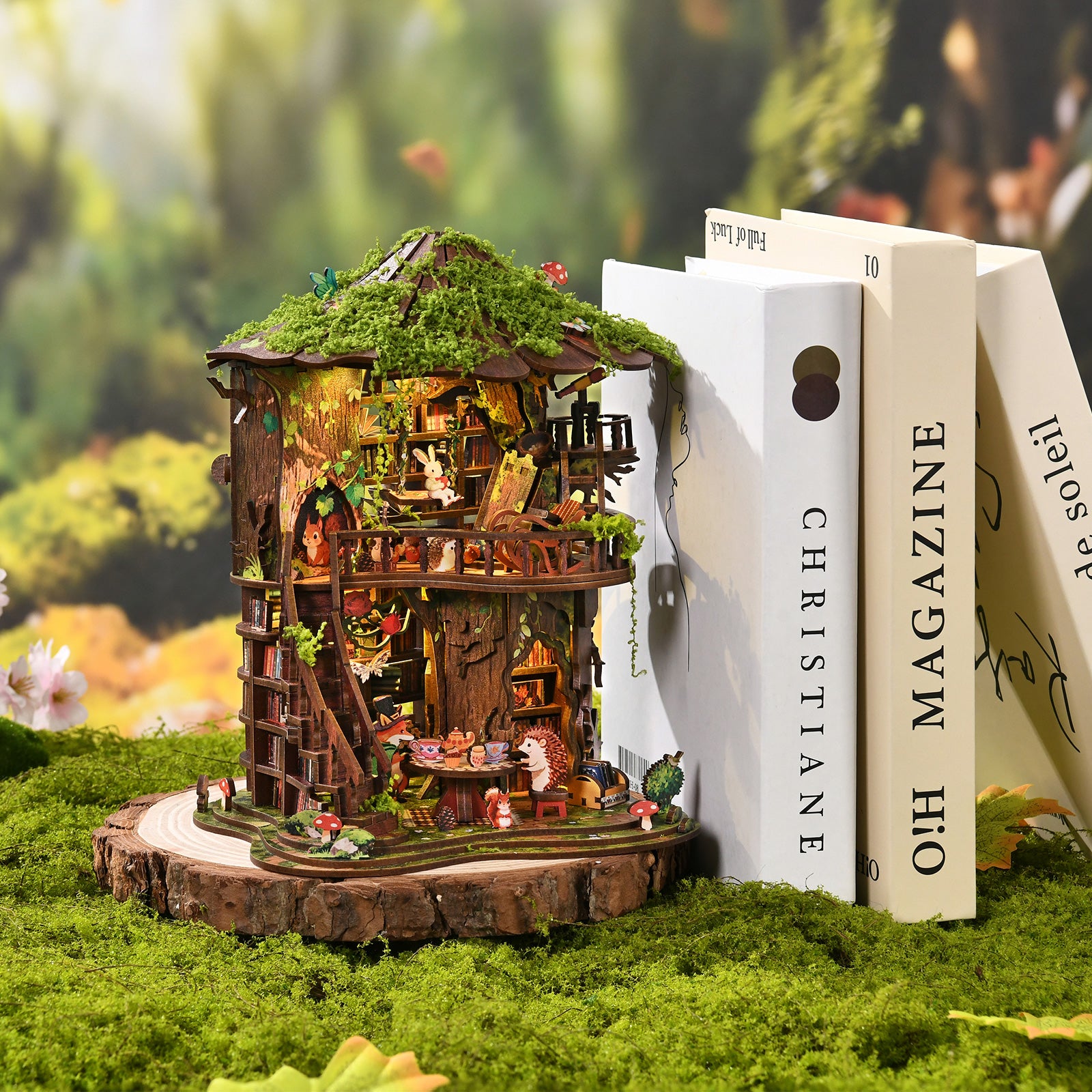 Decorative book set with forest treehouse mini model on a moss-covered base