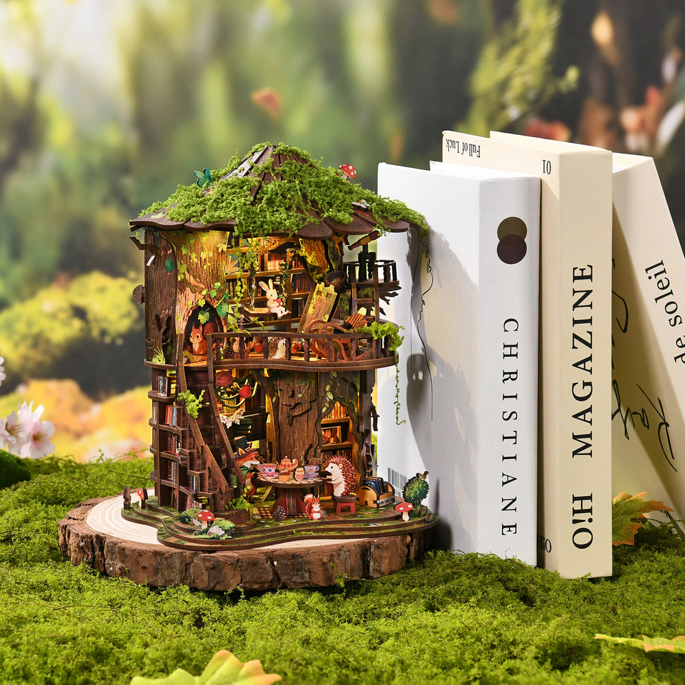Decorative book set with forest treehouse mini model on a moss-covered base