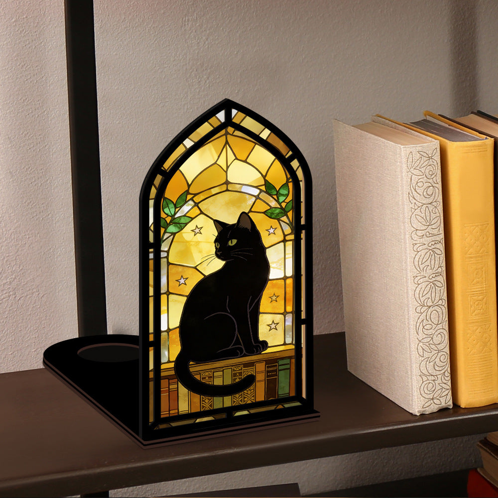 Arched black cat book nook on shelf with warm glowing stained-glass window