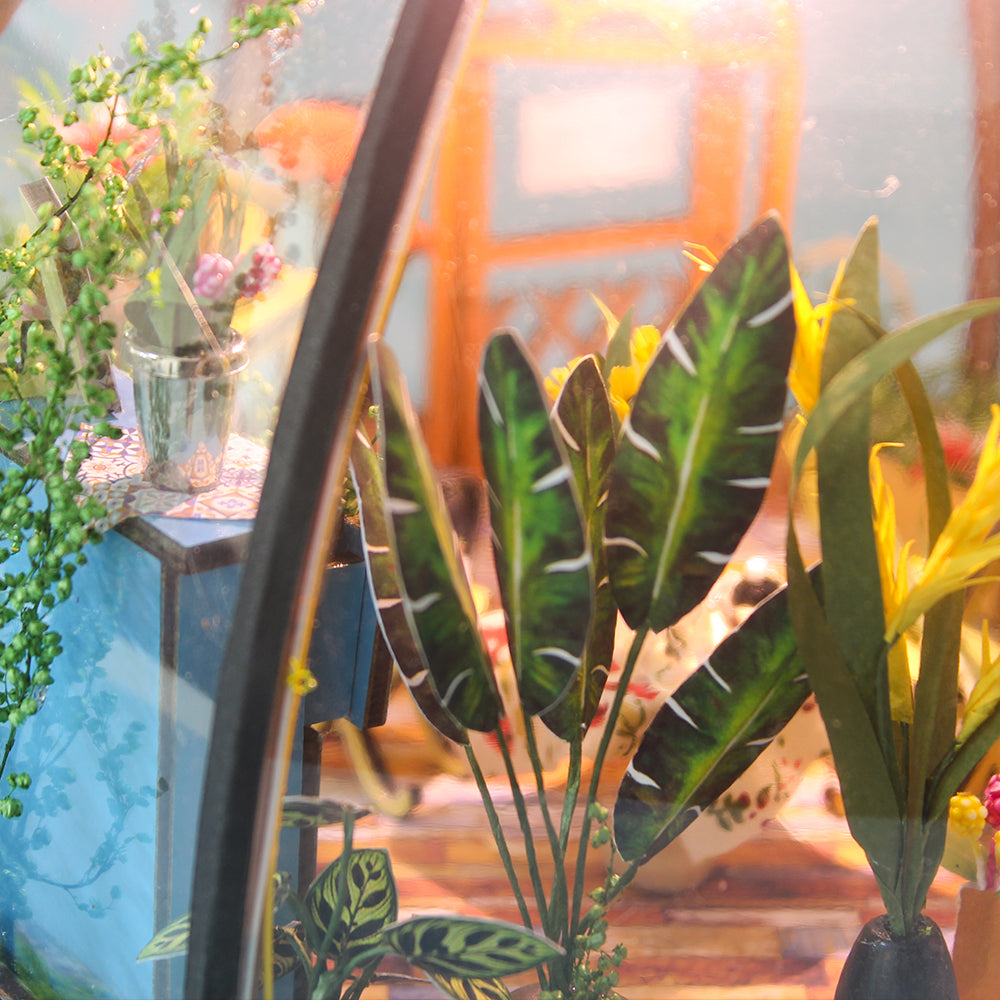 Miniature greenhouse house kit corner with tall green leaves and potted plants on shelves