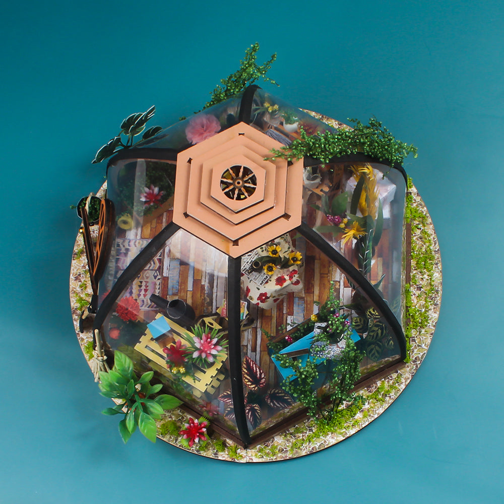 Domed glass greenhouse miniature house kit with colorful flowers and dense greenery.