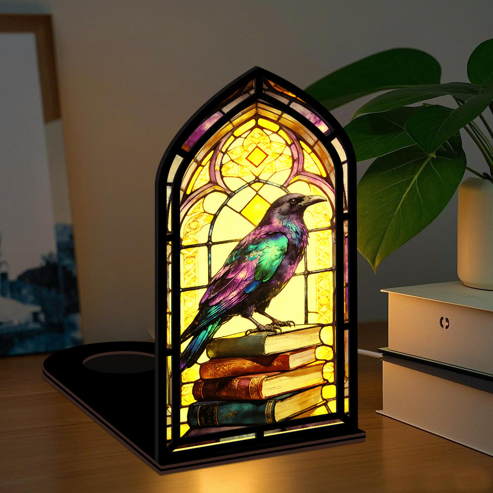 Tabletop arched book nook with warm glow, stained-glass raven perched on books