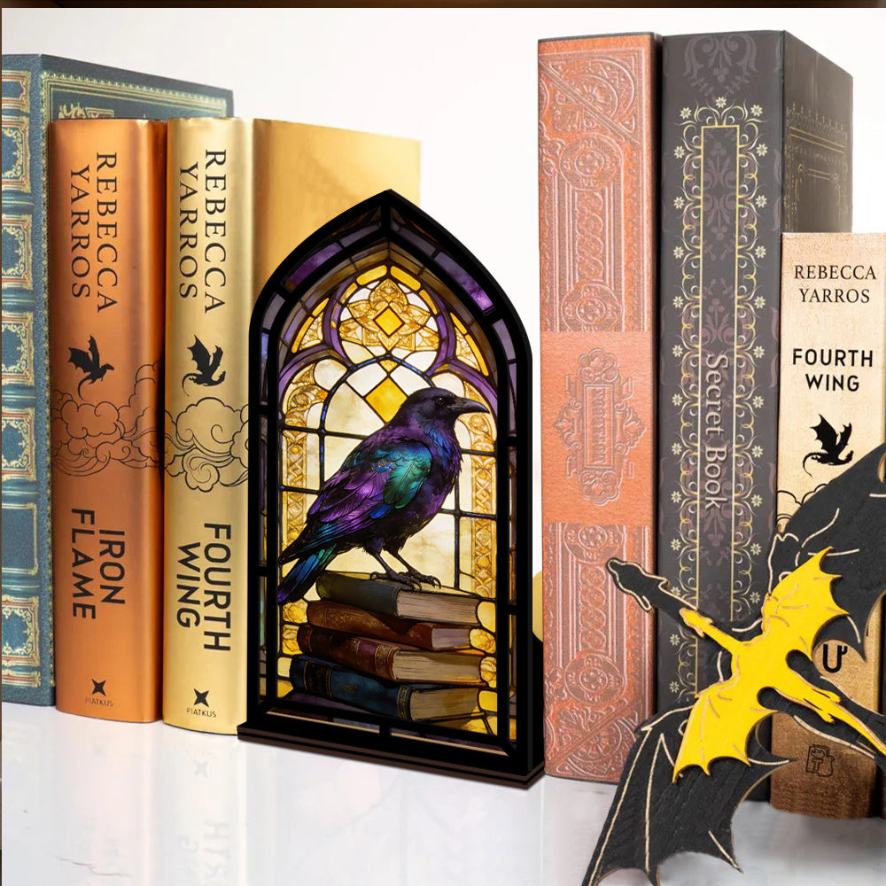 Arched book nook display with candle-like glow and stained-glass raven on books