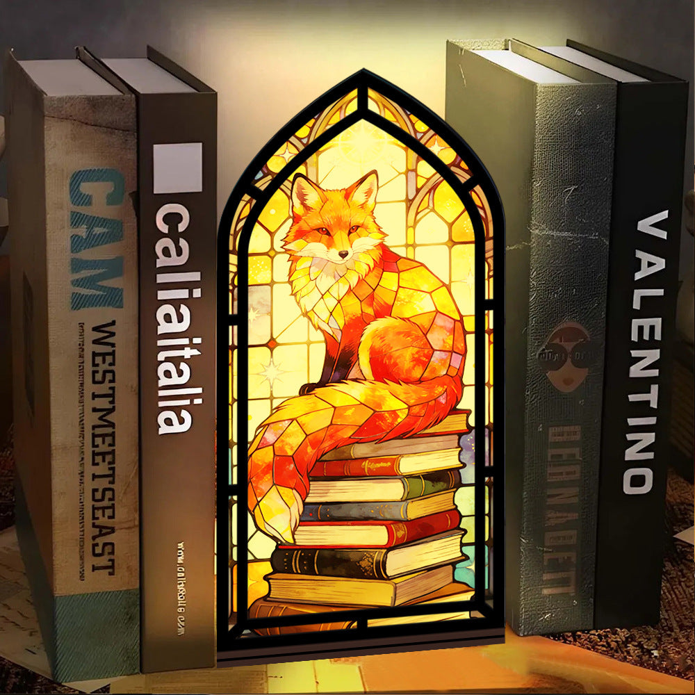 Stained-glass fox book nook with arched frame and stacked books, warm candle glow