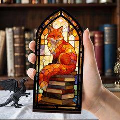 Fox-themed arched book nook with stacked books and stained-glass design, hand holding