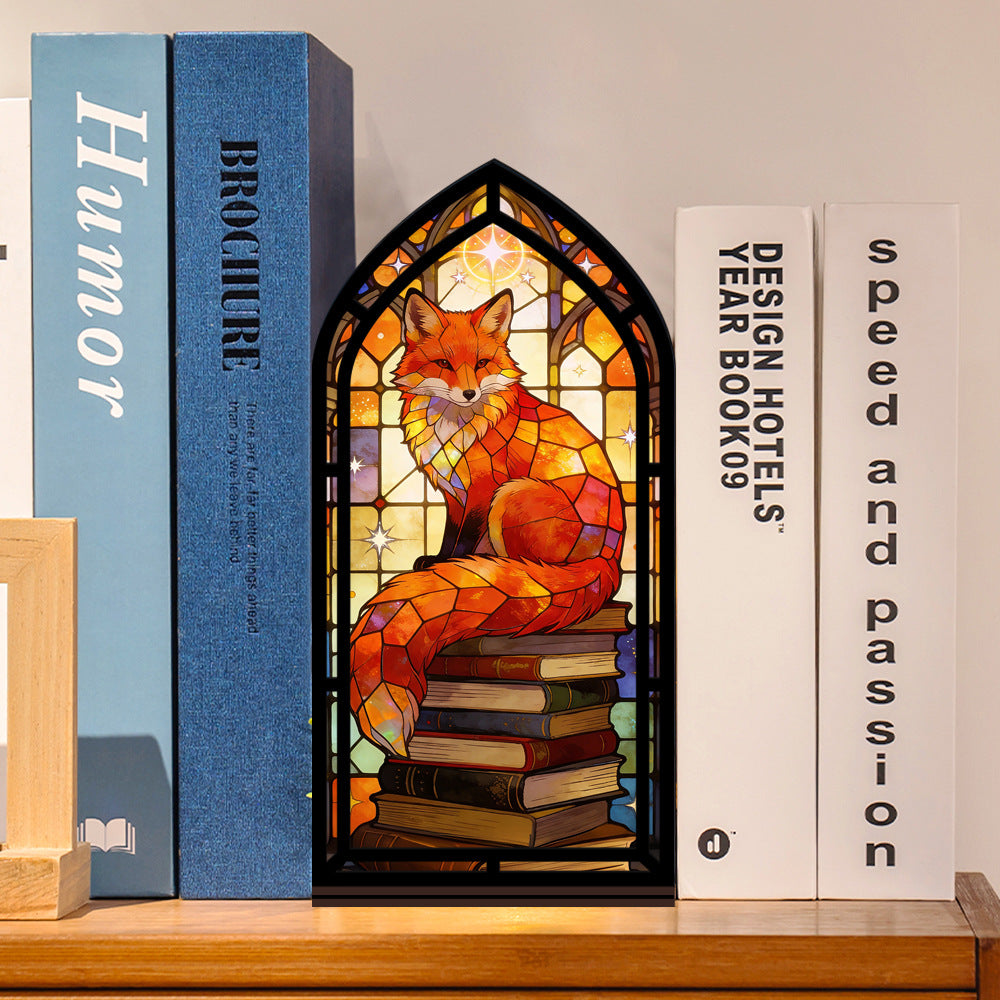 Arched stained-glass fox book nook with stacked books, warm internal light