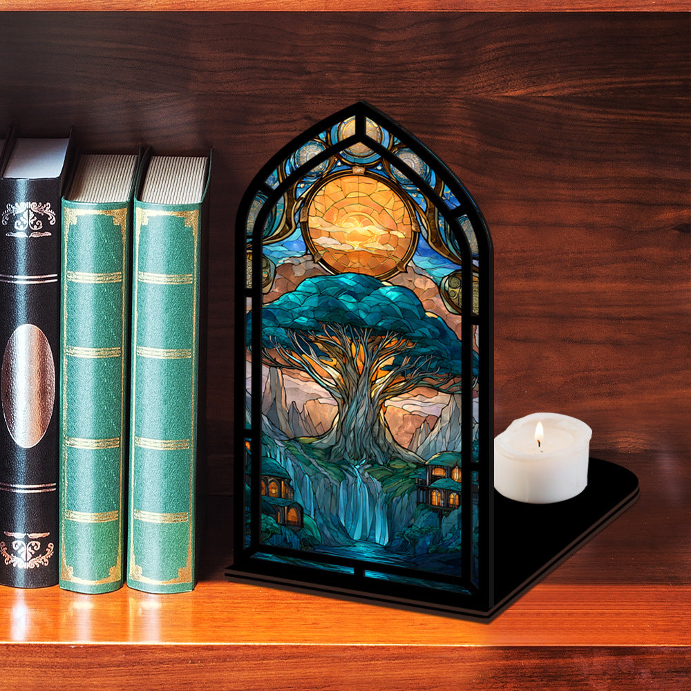Tree-of-life book nook display with arched stained-glass tree panel and lit candle